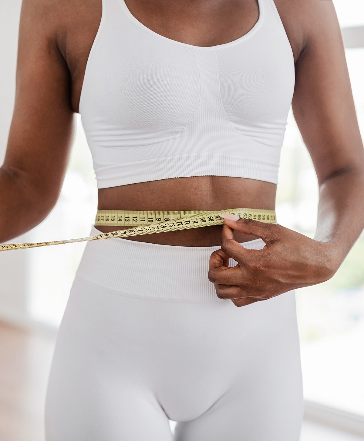 Measuring waist size with a tape measure.