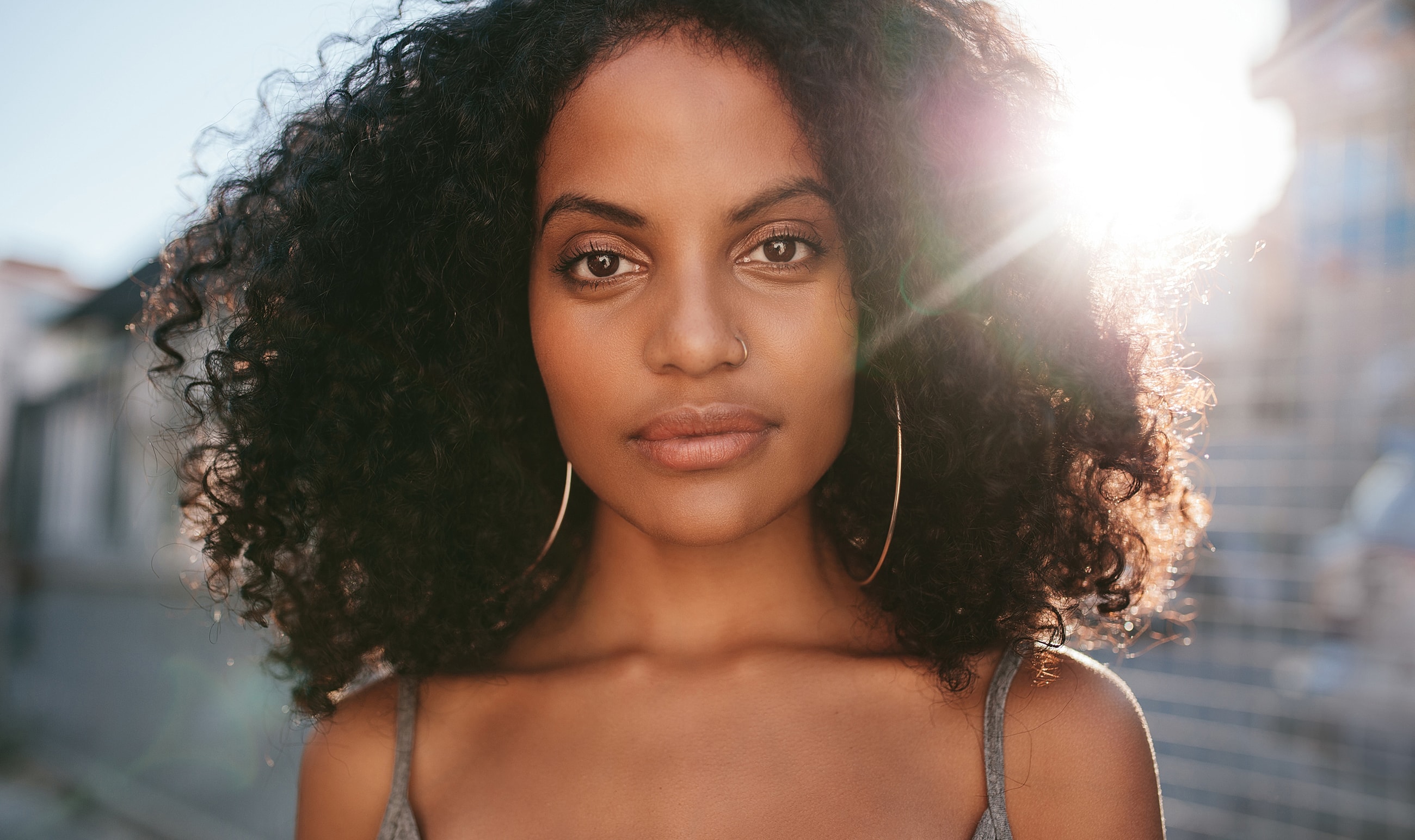 Young woman with curly hair and golden sunlight.